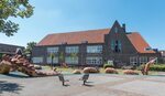 Achtergevel aan het schoolplein met de Grebbedraak.
              <br/>
              Marcel Westhoff, juli 2016